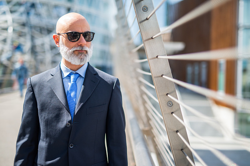 Businessman with sunglasses outdoor in a modern city