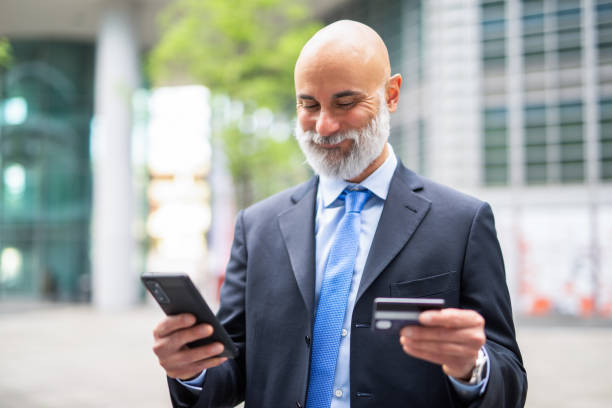 istock Man using his credit card and his cellphone, ecommerce purchase concept 1942093756