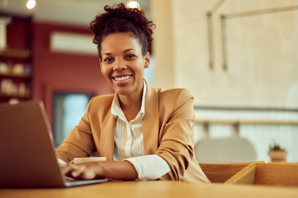 istock A female restaurant manager, working over the laptop, smiling for the camera. 1942093776