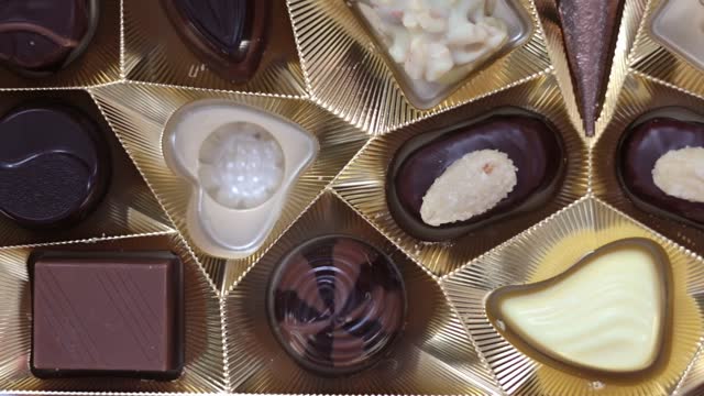 The girl takes a heart-shaped chocolate candy from the box. Valentine's Day Concept