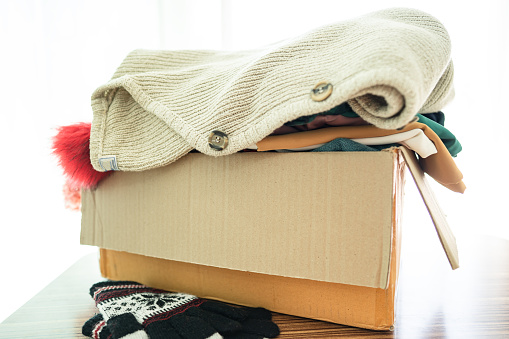 Donation box with used clothes at home to support help for poor people in the world.