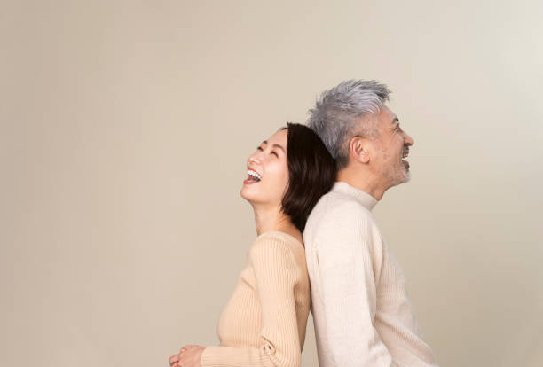 istock A middle-aged couple stands back to back. 1942129103