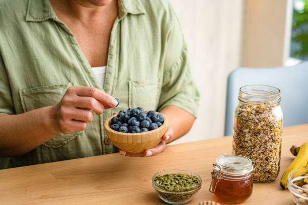 istock Woman eating organic blueberries from a bowl 1942143757