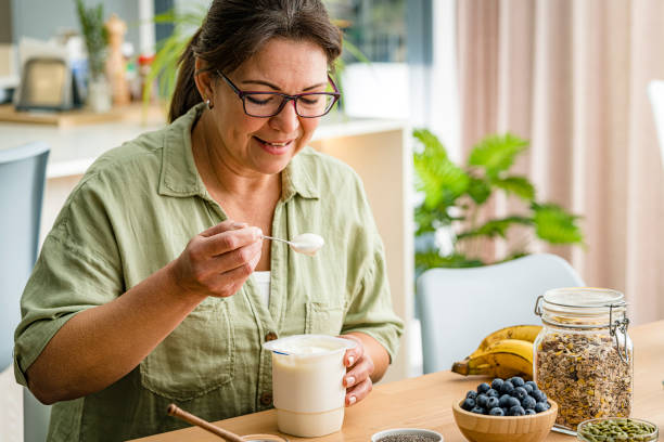 Woman eating greek yogurt Woman eating greek yogurt. High resolution 42Mp studio digital capture taken with Sony A7rII and Sony FE 90mm f2.8 macro G OSS lens eating chia seeds stock pictures, royalty-free photos & images