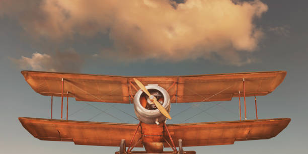 istock Vintage double decker airplane in front of a blue sky with clouds 1942184590
