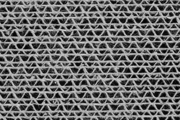 Black and gray background, silver grid structure pattern close-up with holes, cat scratching mat made of paper in close-up macro