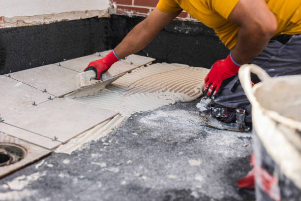 istock worker laying tiles on the floor with cement 1942219988