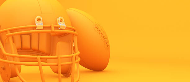 american football helm und ball auf dem orangefarbenen hintergrundstudio. sportliches konzept. - football helmet american football yellow american football uniform stock-fotos und bilder