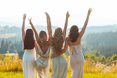 Female friends in elegant dresses looking at the mountains