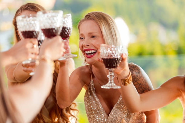 female friends toasting with red wine during party - bride wedding freedom arms raised imagens e fotografias de stock