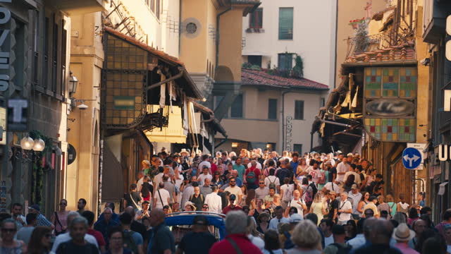 Real time Footage of Pedestrian and Commuter People walking at Ponte Vecchio picturesque medieval arched river bridge area which have various jewelry shop and souvenir shop, Florence, Italy