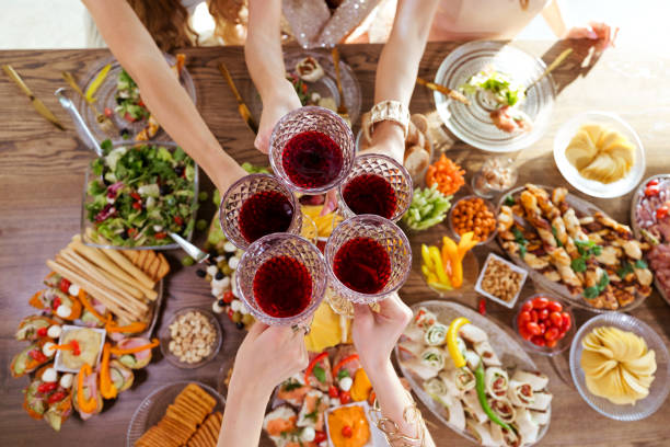istock High angle view of friends toasting with wine glasses above dinner table 1942306865