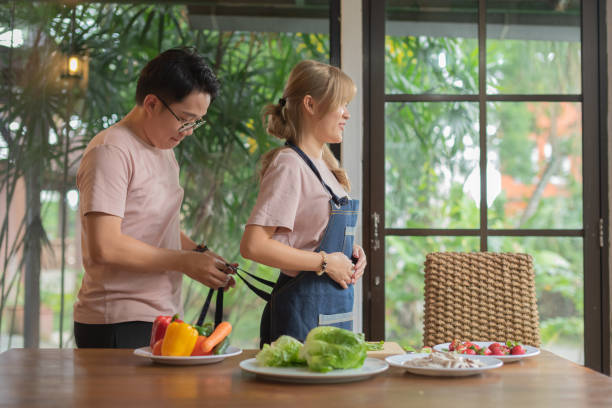 istock Asian husband help wife tie up apron 1942327476