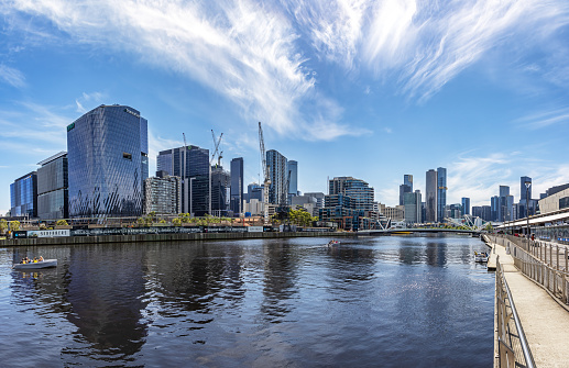 Melbourne, Australia - 18 January 2023: A panorama of the Yarra River with the Seafarers Bridge in the distance. Docklands and South Wharf in Melbourne, Australia