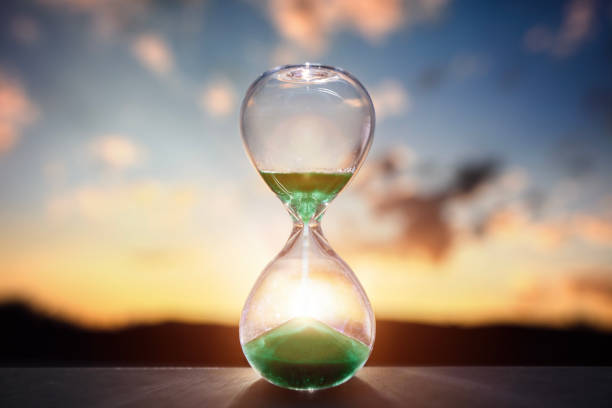 istock Hourglass at sunset background with copy space 1942340471