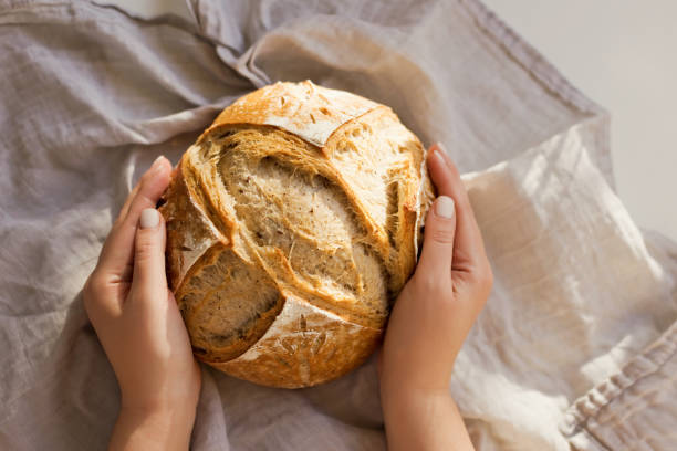 istock Woman holds freshly baked sourdough bread 1942347139
