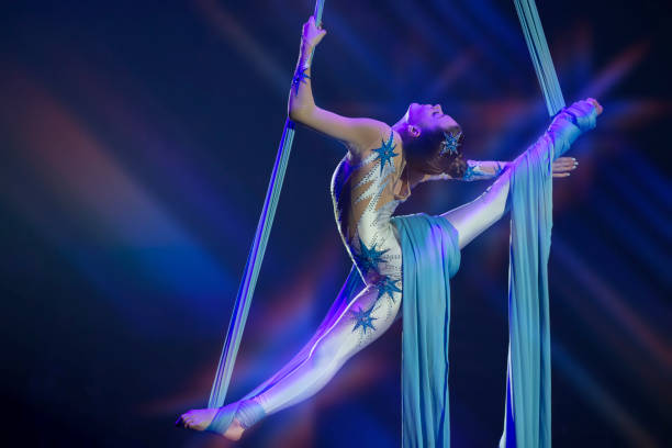 istock Performance by a circus acrobat artist. Girls perform aerial acrobatic elements on fabric. 1942354220