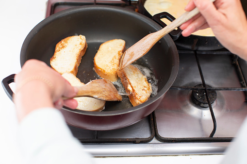 Fry white loaf croutons in a frying pan. Cook breakfast.