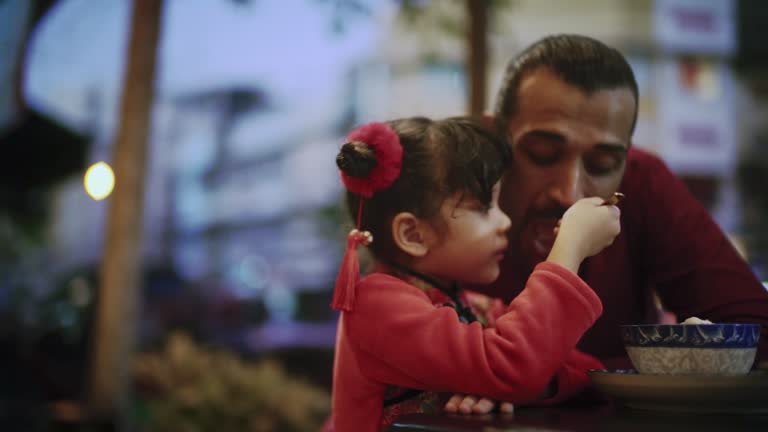 Father and daughter eat dinner