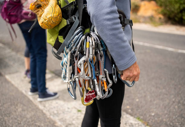 Cropped shot of a woman mountain climbers with backpack and climbing gear standing along the hillside highway road