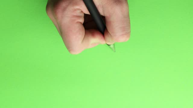 writing with a black pen on a green background