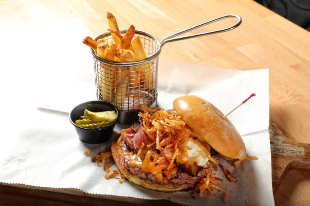 istock Loaded burger dish with fries on wooden table 1942465975