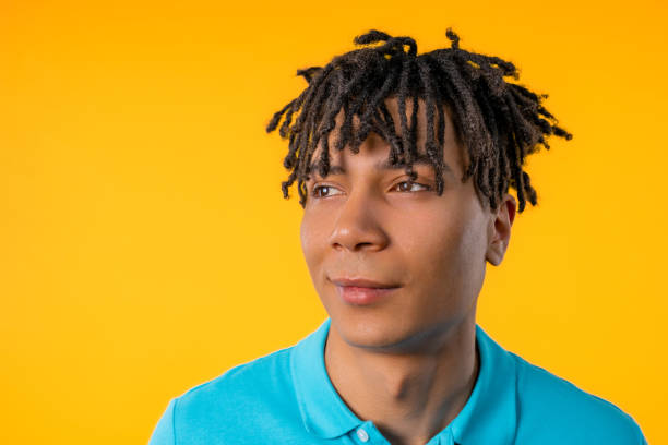 istock Friendly young man on yellow studio background. Copy space. Teenager student guy 1942485225