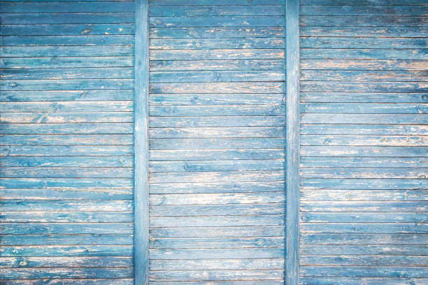 Weathered fading blue painted wooden boards wall closeup as grunge background
