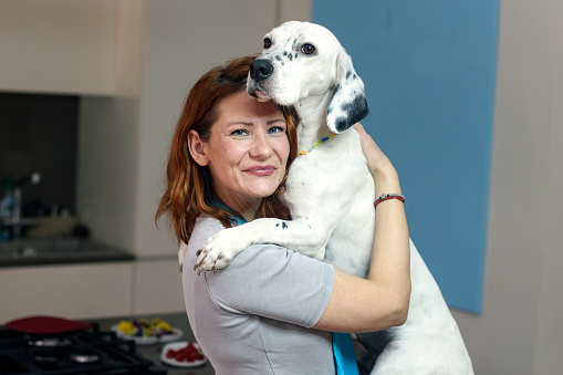 Woman with her dog at home. About 40 years old, Caucasian female.