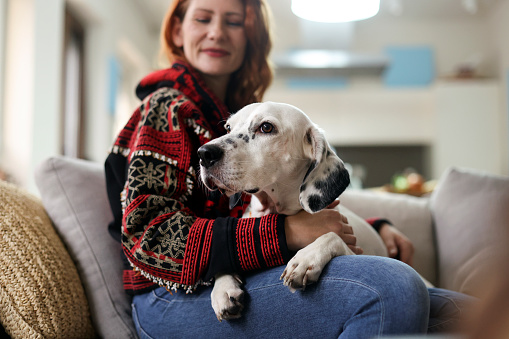 Woman with her dog at home. About 40 years old, Caucasian female.