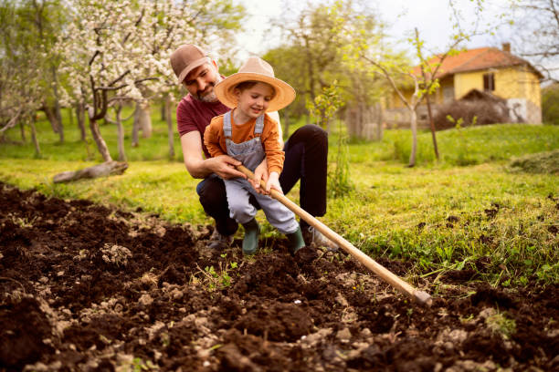 istock Little boy gardening with his father 1942523089
