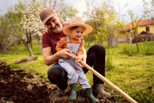 istock Little boy gardening with his father 1942523101