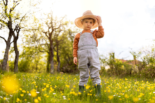 Portrait of a cute little boy with sun hat enjoying a carefree spring day in nature.
