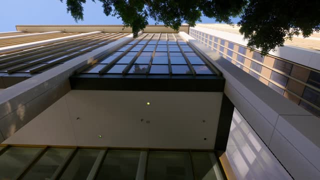 Upward view of modern skyscraper with a dynamic perspective in 4k