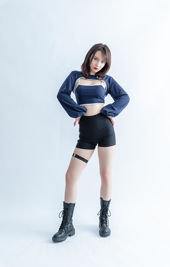 Asian woman in a blue crop top and black shorts