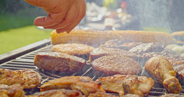 istock Man sprinkling spice on meat 1942581979