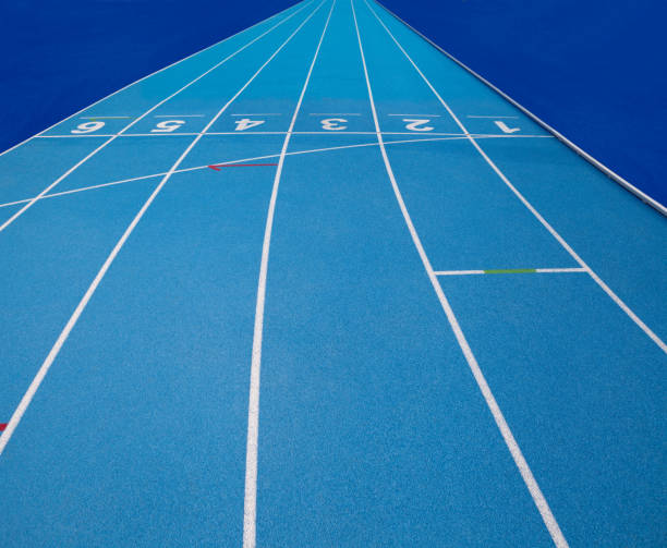 istock Olympic track lanes with white stripes and start and finish numbers, empty Blue background for copy space, concept of physical sports and running, symbolizing commitment and paths to goals 1942596260