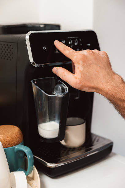 istock Vitiligo Hand Crafting Coffee with the coffee machine in the background 1942598901
