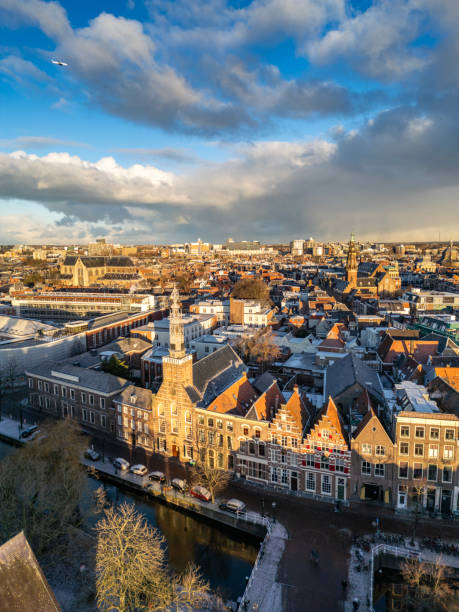 Early morning winter sun hitting the historical centre of Leiden, Rapenburg canal and his houses. Above a dramatic winter sky.