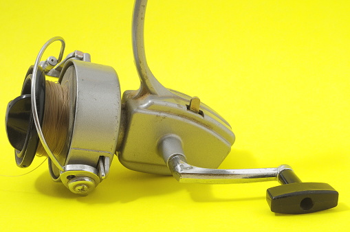 One Vintage Old Fishing Reel on a Colored Background