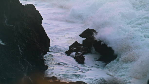 istock Splashing waves hitting cliff on stormy day. Powerful ocean breaking coastline 1942689565