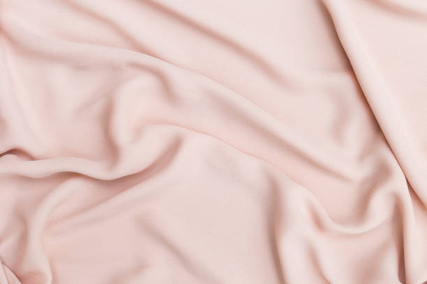 istock Closeup waving pink fabric background 1942690083