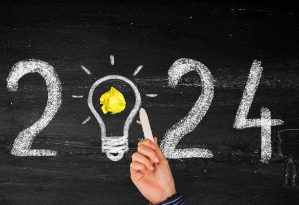 istock Light Bulb  with new year 2024 on chalkboard 1942752906