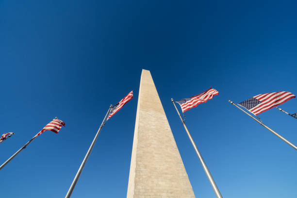 istock Several American flags and the Washington Monument, looking up 1942754461