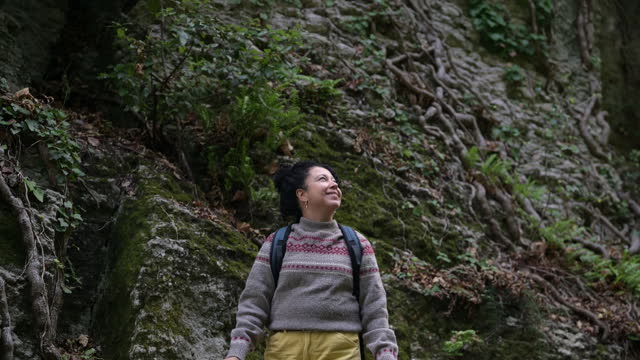 Cheerful backpacker in a mountain forest.