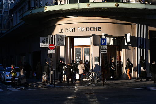 Paris, France-01 18 2024: People passing in front of an entrance to the Bon Marché department store in Paris, France.