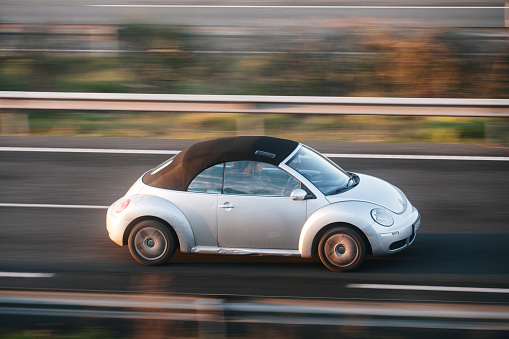 Santander, Spain - 12 January 2024: A Volkswagen New Beetle cabrio in motion on a highway