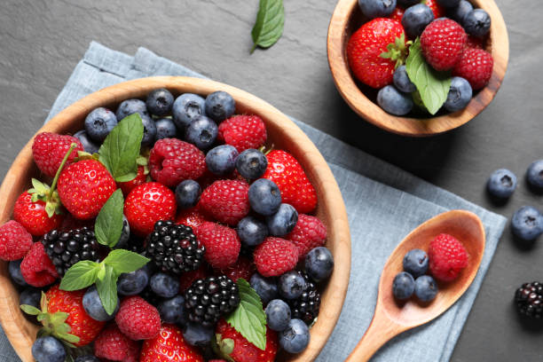 istock Many different fresh ripe berries on black table, flat lay 1942803619