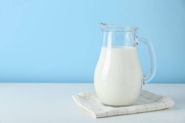 istock One jug of fresh milk on white table against light blue background, space for text 1942814127