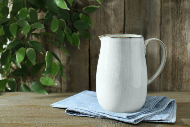 istock One white jug on wooden table, space for text 1942814146